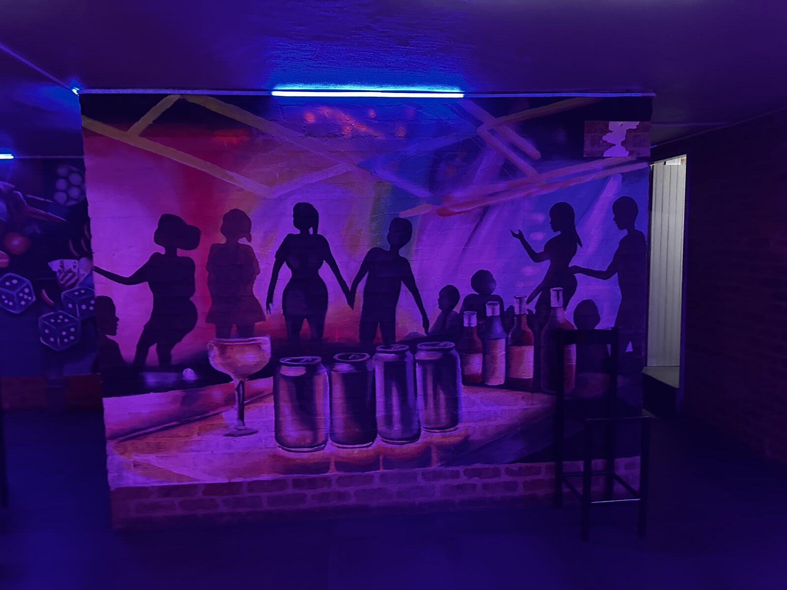 UV-lit party mural on the wall at Cheeky Tiger Midrand