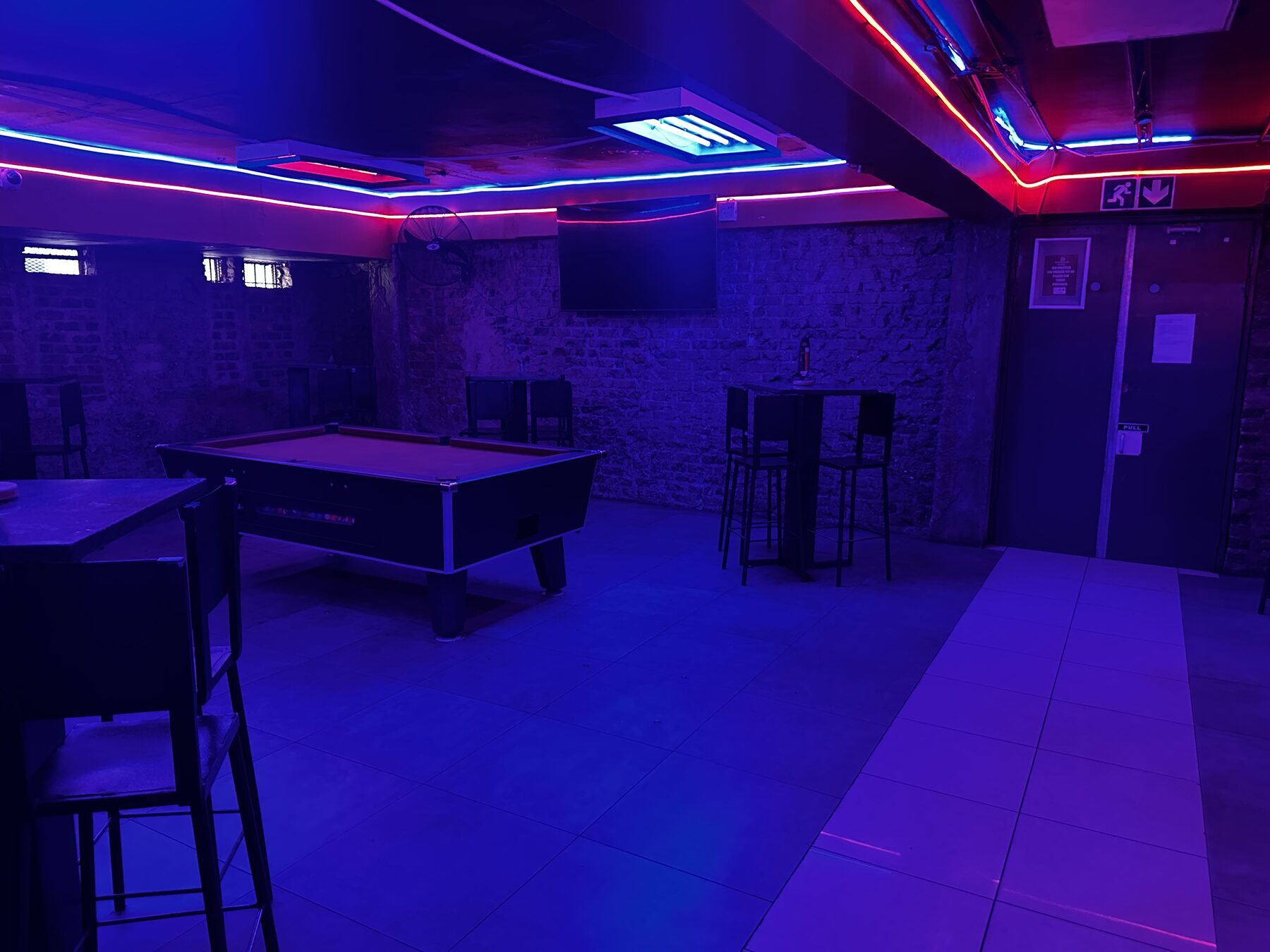 Pool room with tables under neon ceiling lighting at Cheeky Tiger Diepkloof Hotel