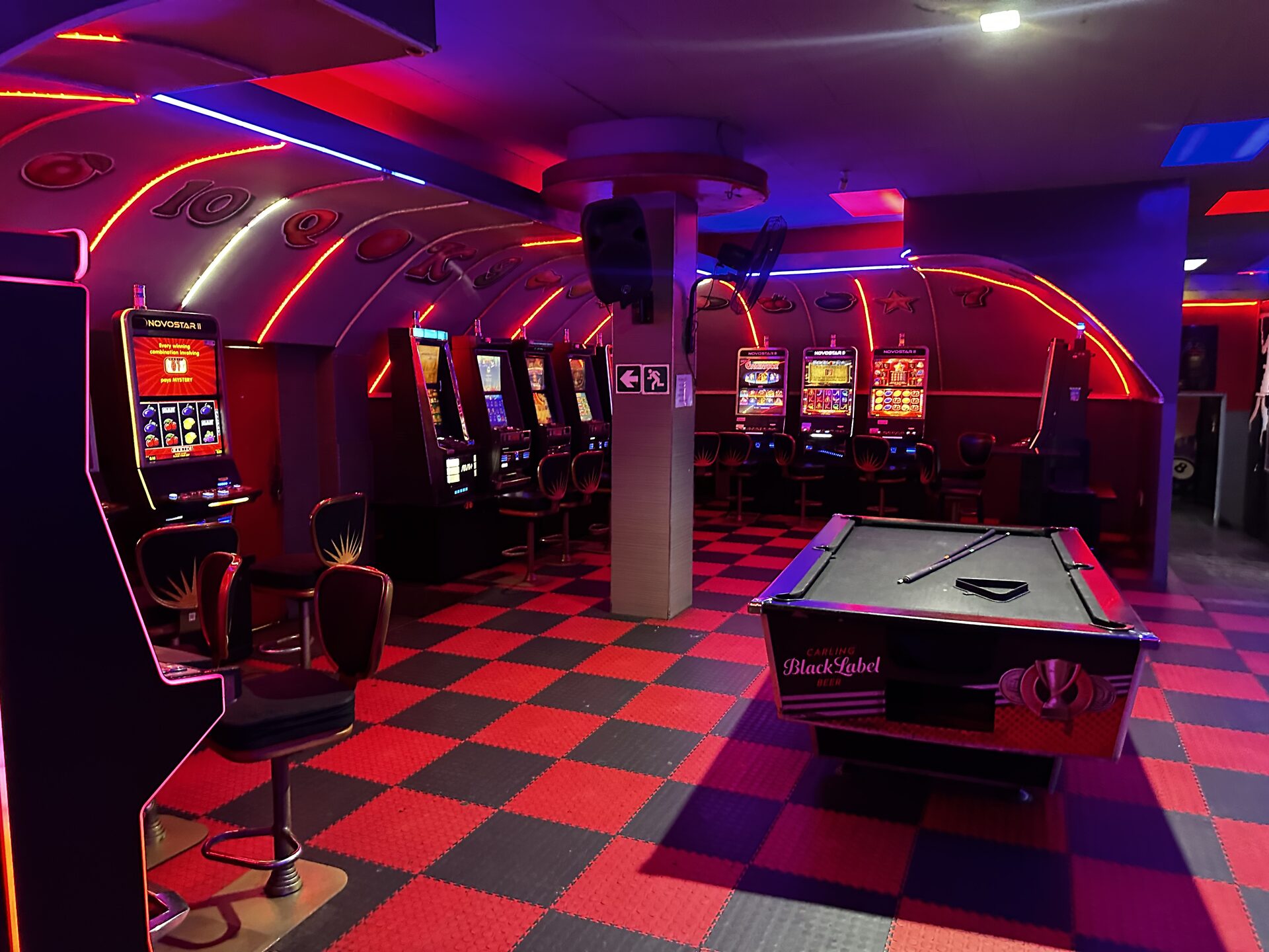 Slot machines and pool table on the checkered gaming floor at Cheeky Tiger Kempton Park