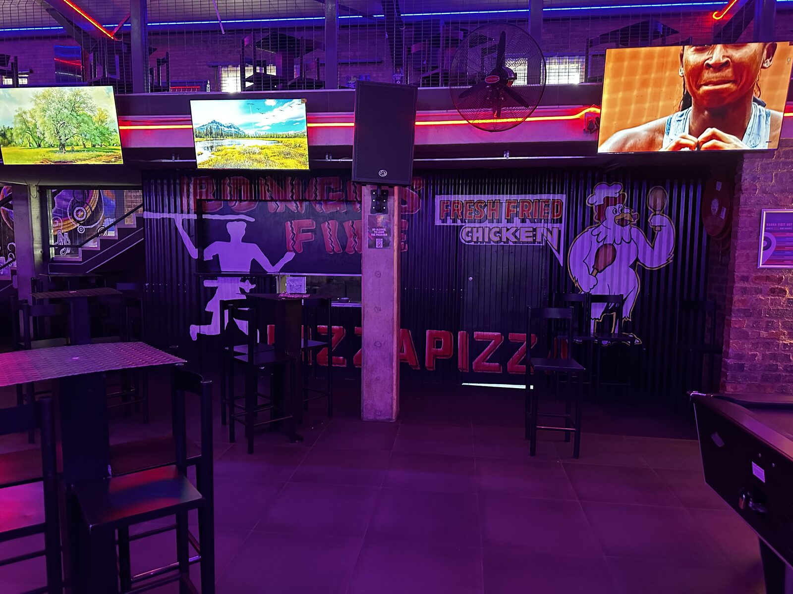 Bonkers Fire kitchen counter with fresh fried chicken and pizza signage at Cheeky Tiger Midrand