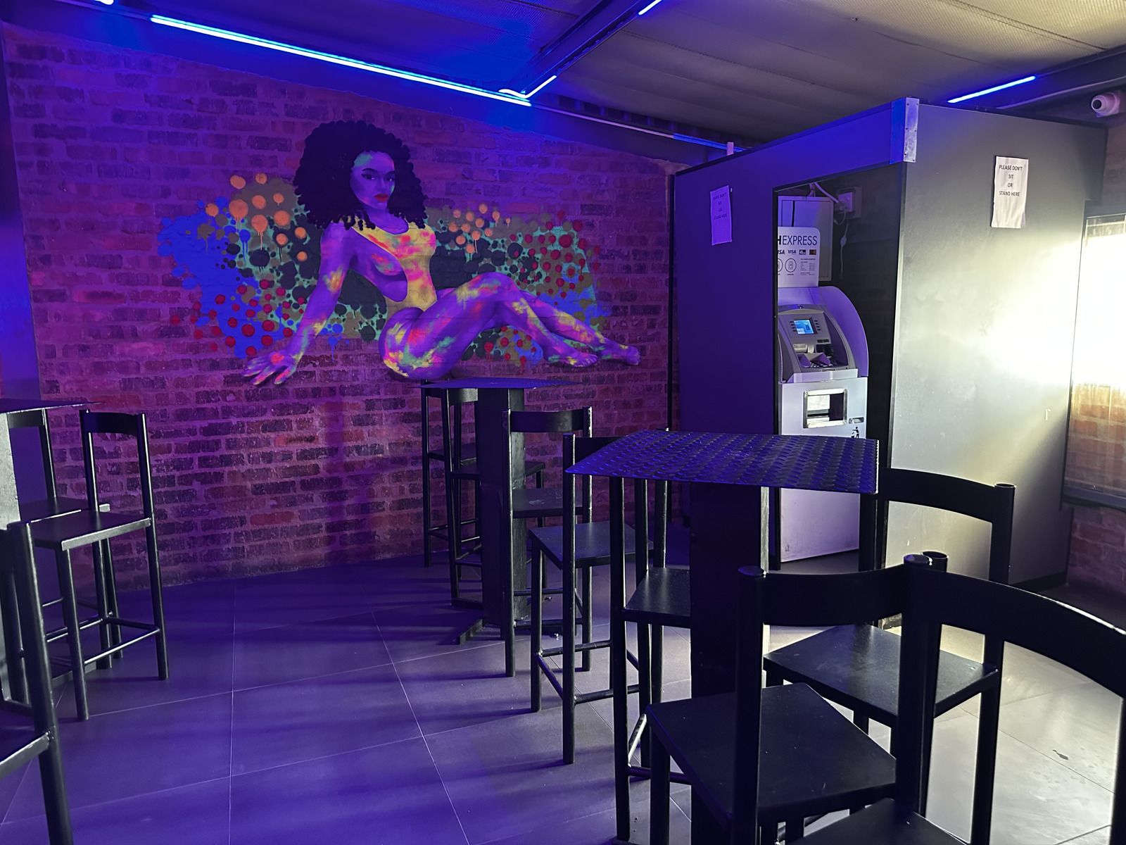 UV mural wall and high tables beside the ATM at Cheeky Tiger Midrand