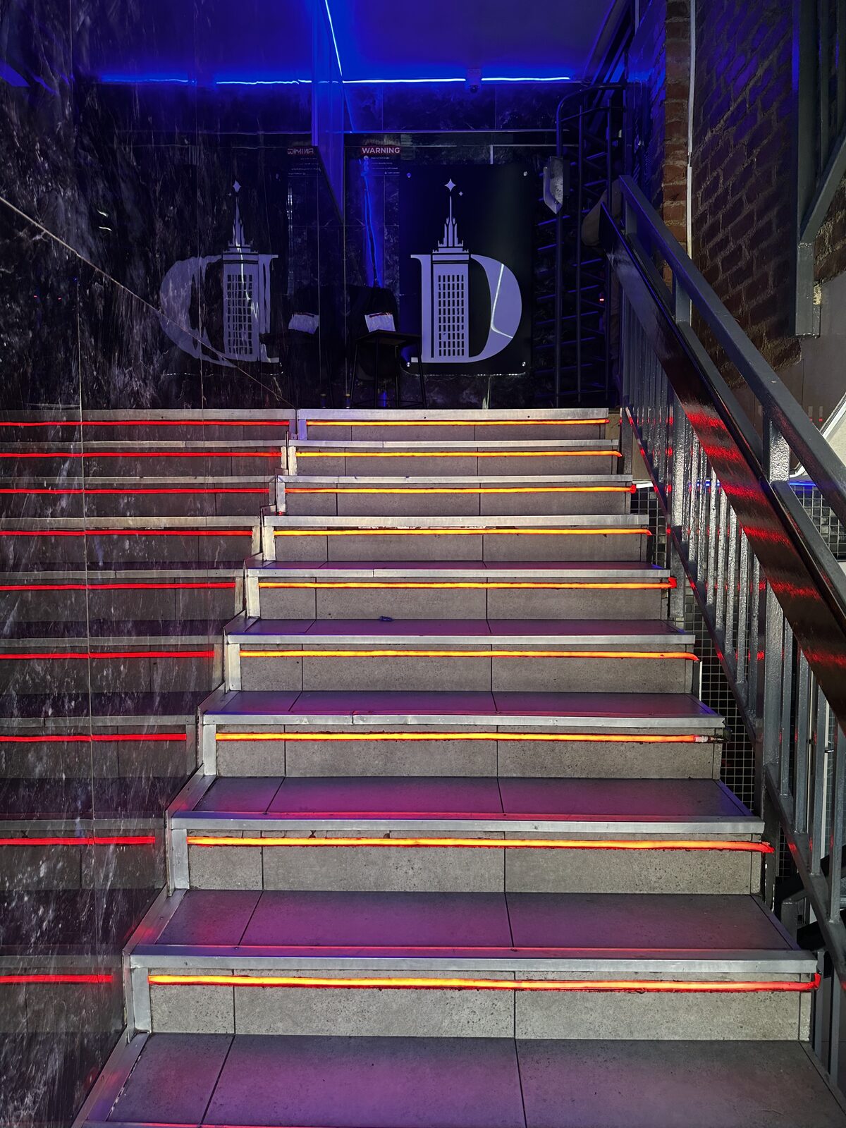 Entrance staircase lit with red and amber neon strips at Cheeky Tiger Diepkloof Hotel