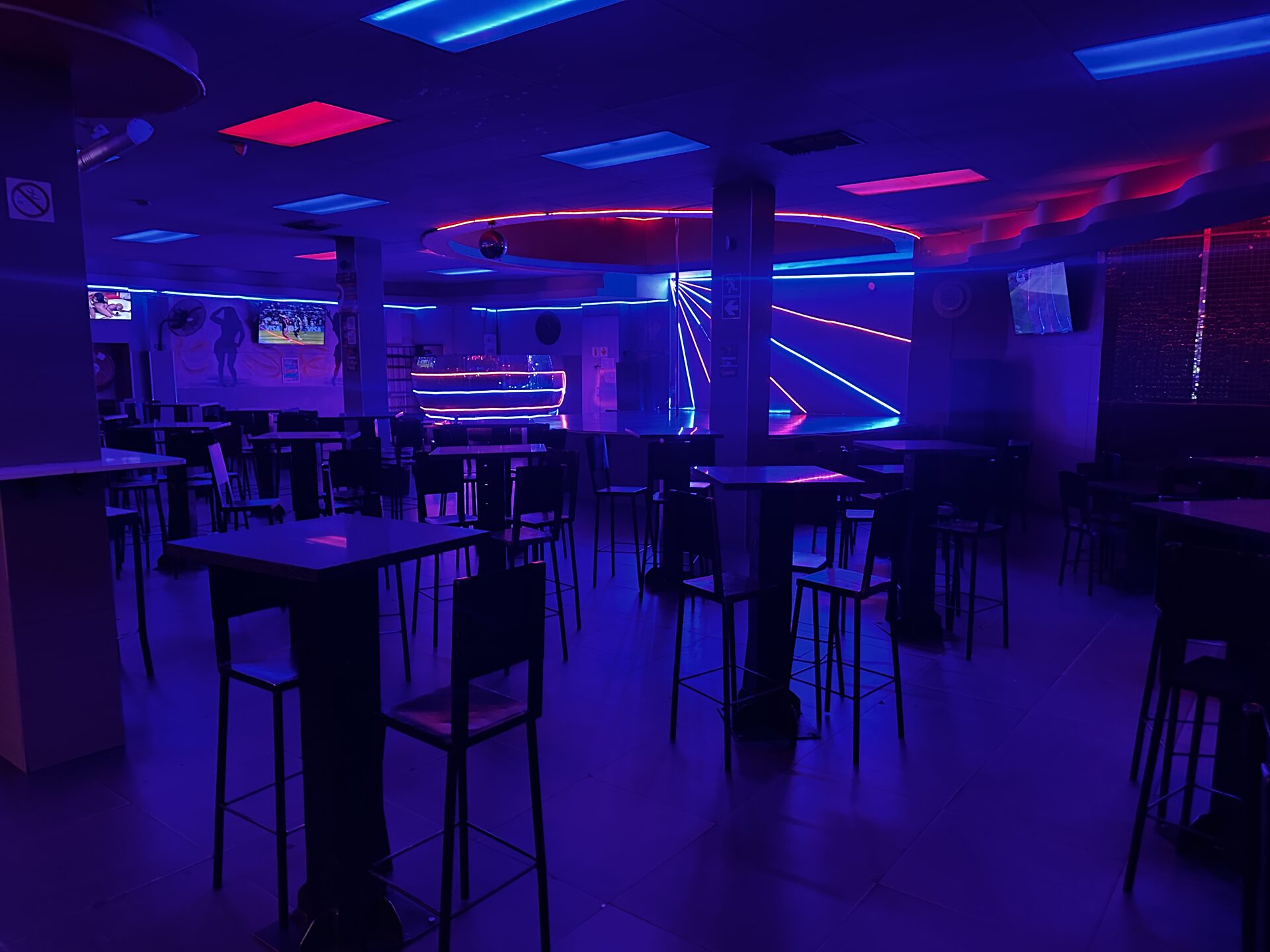 Main floor with high tables, neon ceiling and the stage at Cheeky Tiger Kempton Park