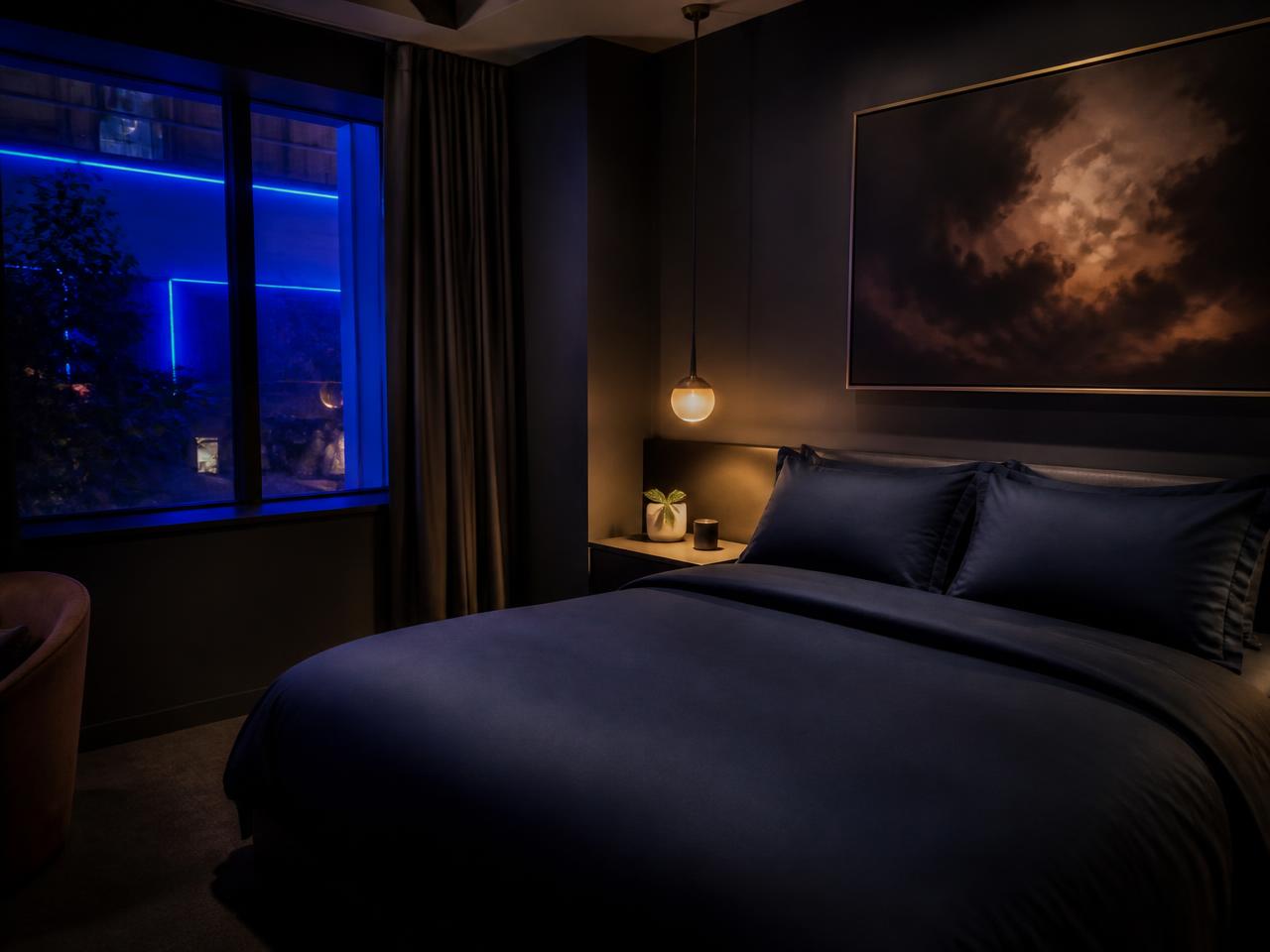 Hotel guest room with navy bedding and warm lamp light at Cheeky Tiger Diepkloof Hotel
