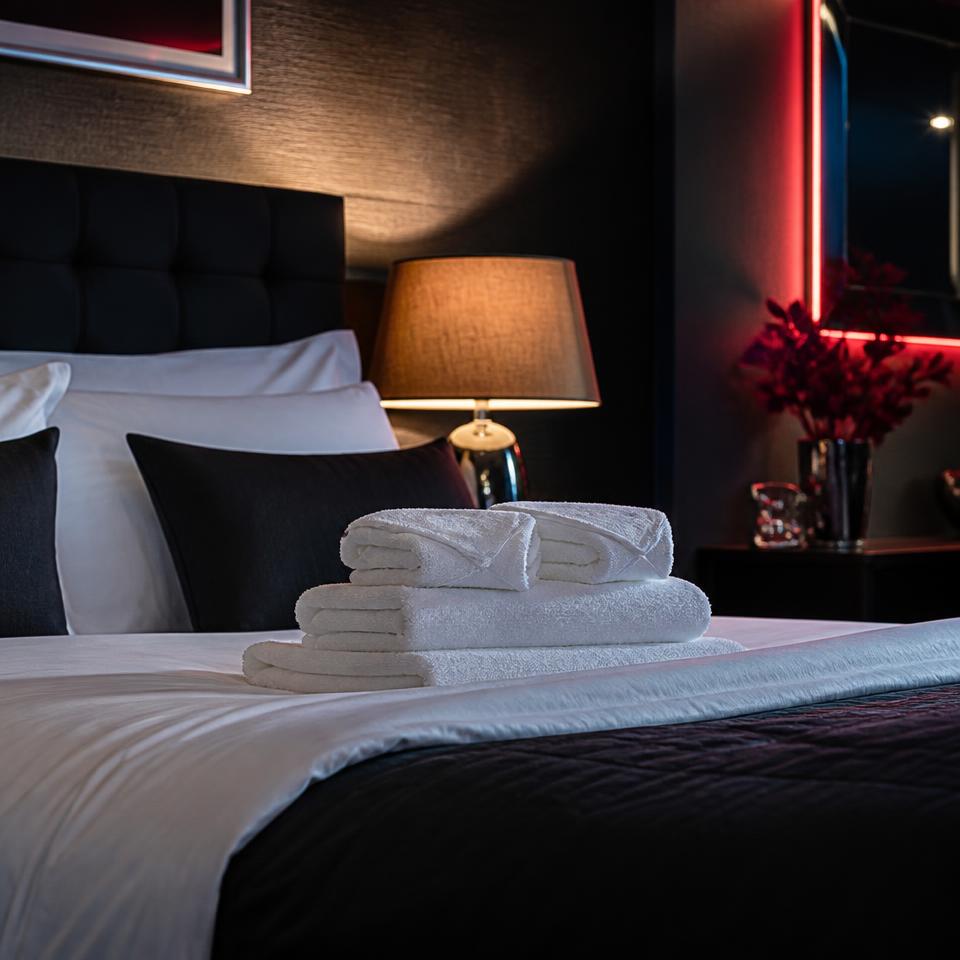 Fresh linen and towels prepared in a hotel room at Cheeky Tiger Diepkloof Hotel